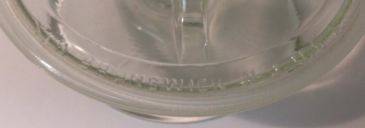 The embossing on the mystery object storage jar lid says "New Brunswick, N.J.," which makes it earlier than 1933. 
