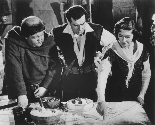 Friar Tuck and Robin Hood watch Maid Marian drawing a map in baking flour -- a very 1950s thing to do in a show set in the 1100s.  Photo from our archives.  