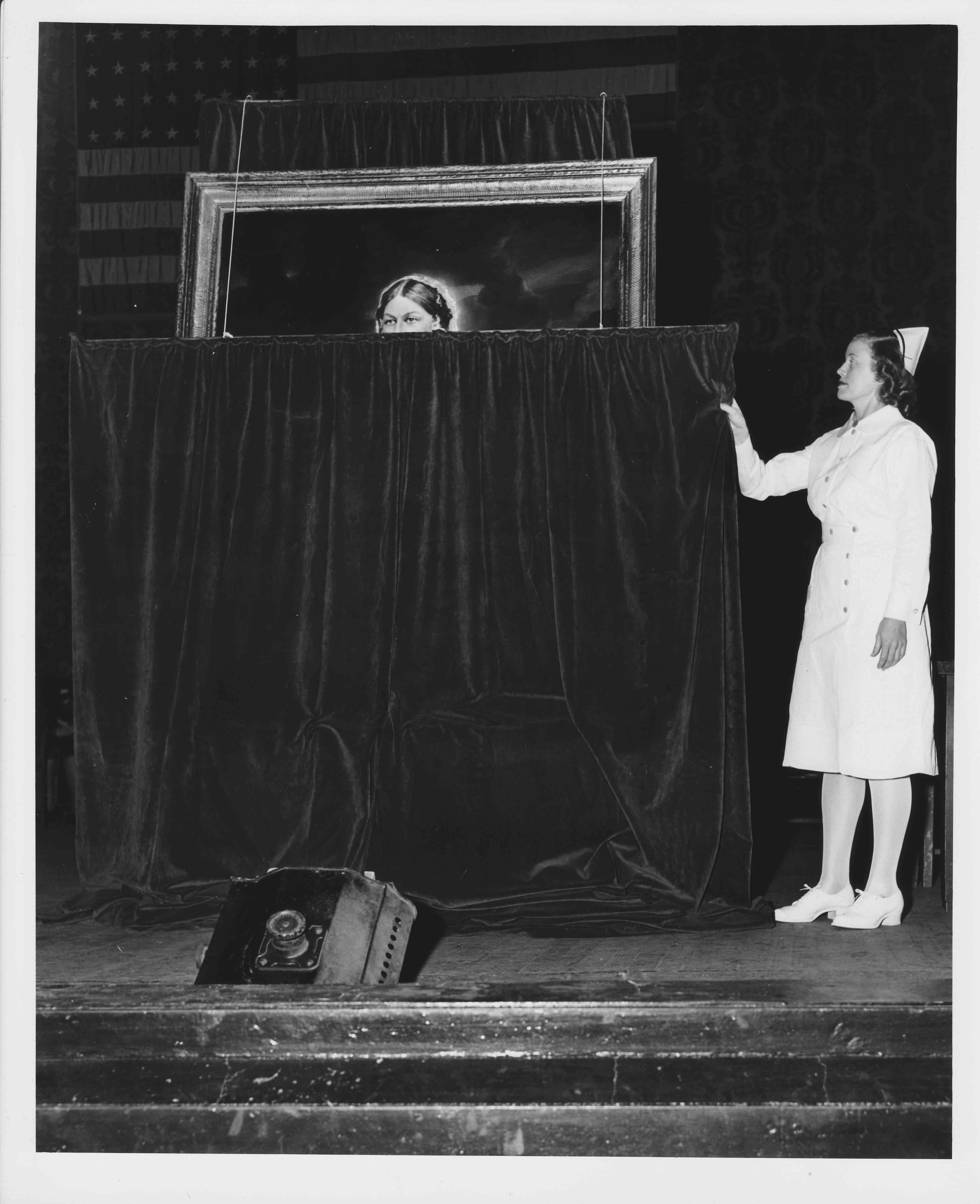 “Typical American Nurse of the Year” Elizabeth B--- begins to unveil the portrait of Florence Nightingale before an audience of nurses.  Image courtesy: Johnson & Johnson Archives.